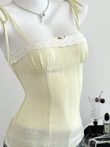 Elegante top giallo pallido con rifinitura in pizzo, taglio slanciato e dettagli a fiocco.