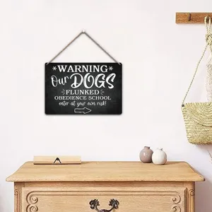 Wooden hanging sign detail showing rustic black board with funny English warning quote.