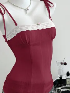 Primo piano dettaglio della canotta borgogna con bordo in pizzo bianco e spalline chic.