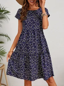 Detailed view of women's navy blue floral short sleeve tiered dress on model, elegant style.