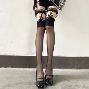 Detail shot of black over-the-knee stockings with lace trim, bows and garter straps.