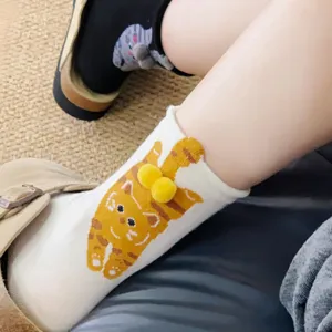 Close-up of cute 3d cat socks with yellow plush balls detail worn on feet comfortably.