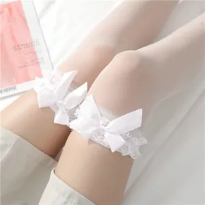 Calze trasparenti bianche sopra il ginocchio con delicato bordo in pizzo e fiocchi eleganti.
