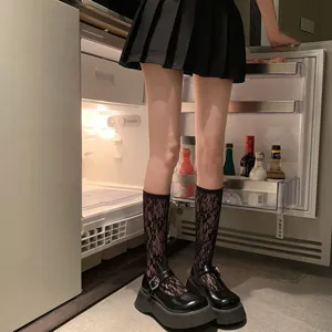 Vue détaillée de chaussettes mi-mollet en dentelle noire pour femmes avec chaussures.