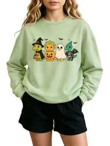 Close-up detail of the cute Halloween dinosaur graphic printed on the green long sleeve sweatshirt.