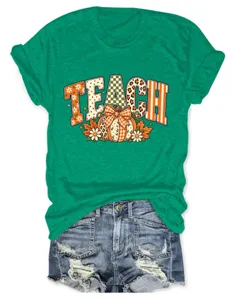 Dames groen t-shirt met korte mouwen en TEACH pompoen strik grafische casual top.