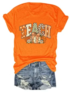 Gedetailleerd overzicht van het oranje teach pompoen print t-shirt gecombineerd met denim.