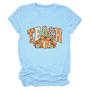 Lichtblauwe korte mouw T-shirt met TEACH grafische print en schattig herfst pompoen ontwerp.