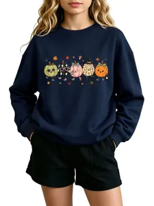 Detailed view of the dark blue autumn sweatshirt featuring cute cartoon pumpkin graphic print.