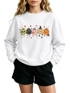 Close-up detail of the cute autumn pumpkin graphic print on the soft white crewneck sweatshirt.