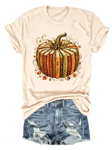 Detailaufnahme des herbstlichen Kürbis-Buch-Grafikdrucks auf weichem beige T-Shirt mit Jeans-Shorts.