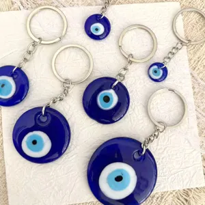 Turkish evil eye glass keychain detail view, blue Nazar amulet bag charm jewelry pendant.