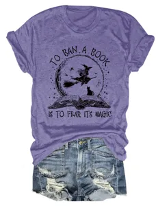 Detail view of the purple short-sleeve t-shirt featuring a witch and book graphic design.