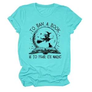 Close-up detail shot of the turquoise t-shirt showing the witch book print and soft fabric.