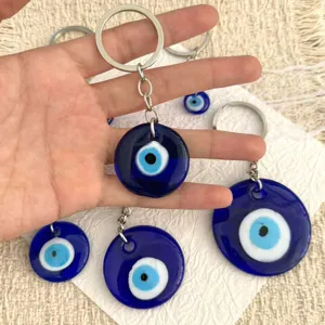 Detail view of Turkish evil eye glass keychain with metal ring, traditional blue amulet.