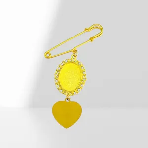 Detailed view of gold tone safety pin brooch featuring vintage lace oval frame and heart charm.