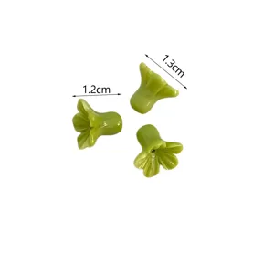Detail view of green shell powder trumpet flower loose beads for DIY jewelry accessories.