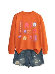 Close-up detail view of the cute radiology theme print graphic on the orange long sleeve sweatshirt.