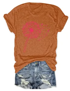 Detail view of orange short sleeve t-shirt with pink dandelion graphic and denim shorts.