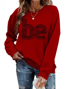 Détail de sweat rouge avec imprimé graphique de mots inspirants, manches longues et col rond.
