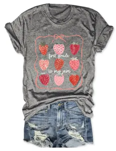 Détail de t-shirt gris chiné montrant un joli imprimé graphique de fraises avec texte ludique.