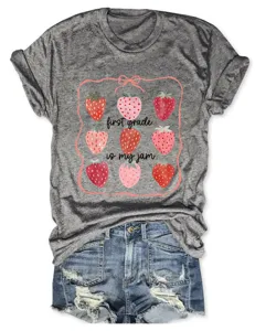 T-shirt a manches courtes gris avec motif de fraise et texte vue de detail feminine.