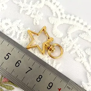 Gold star metal keychain clasp detail, swivel lobster hook for DIY craft jewelry making.