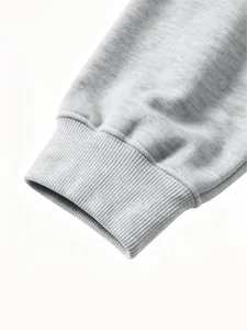 Close-up detail of grey kids sweatshirt ribbed cuff, showing fine knit texture and stitching.
