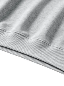 Detail view of grey heather children sweatshirt hem, soft cotton blend fabric texture and ribbing.