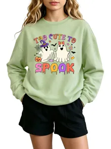 Close-up detail of the cute Halloween ghost graphic printed on the light green long sleeve sweatshirt.