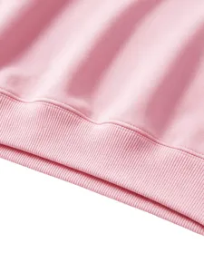 Pink children sweatshirt ribbed hem detail, soft knit fabric texture closeup view.