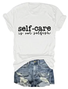 Close-up detail van het casual witte t-shirt met inspirerende tekst en gescheurde spijkerbroek.