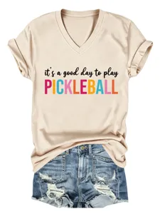 Detail view of casual beige V-neck short sleeve t-shirt with graphic text and denim shorts.