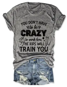 Damen graues Grafik Kurzarm T-Shirt kombiniert mit blauen Jeansshorts im Destroyed-Look.