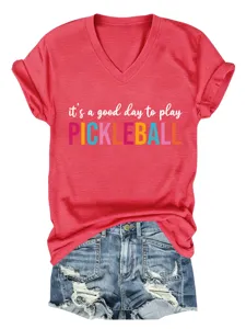 Detailed view of red v-neck short sleeve t-shirt with pickleball text graphic and blue denim shorts.