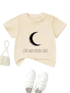 Close-up detail of beige kids short sleeve t-shirt featuring a crescent moon and text graphic.