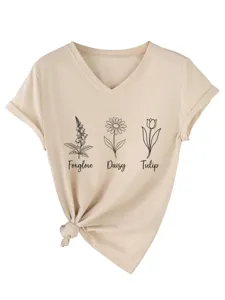 Close-up van botanische print V-hals korte mouw t-shirt met stijlvol knoopdetail aan de zoom.