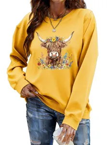 Close-up detail showing the front chest print of the yellow sweatshirt with a floral cow.