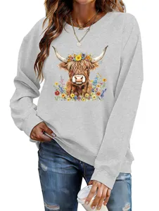 Close-up front view of women grey crewneck sweatshirt featuring cute highland cow floral print detail.