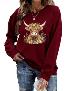Women's long sleeve maroon sweatshirt featuring a cute highland cow and colorful floral graphic print.