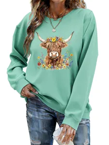 Closeup detail of the casual women's green sweatshirt featuring a cute highland cow floral graphic print.