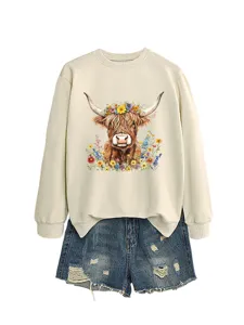 Women beige sweatshirt with cute floral Highland cow graphic and distressed denim shorts outfit.