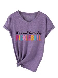 Close-up detail of purple V-neck short sleeve t-shirt featuring playful pickleball slogan.