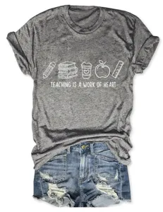 Détail de t-shirt graphique gris pour enseignant avec icônes d'école et citation inspirante.