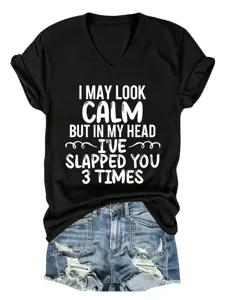 Funny quote print detail on black V-neck t-shirt with distressed denim shorts flat lay.