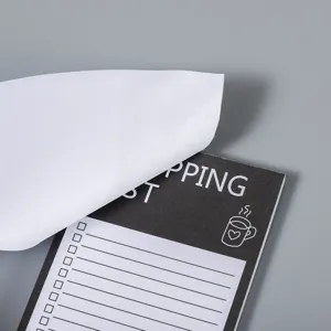 Gros plan détaillé du bloc-notes magnétique de liste de courses avec du papier ligné détachable.