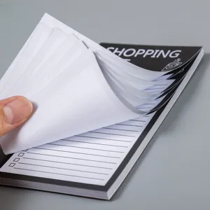 Détail de bloc-notes aimanté avec pages lignées et détachables pour liste de courses au frigo.