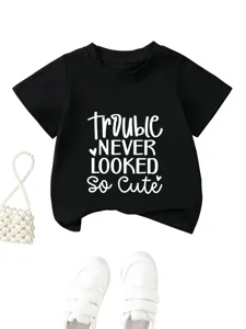 Primo piano del t-shirt nero per bambini con stampa bianca carina, stile casual.