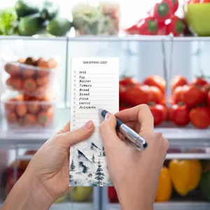 Close-up detail of a magnetic shopping list notepad with watercolor mountain design in fridge.