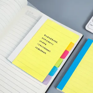 Primer plano de lengüetas adhesivas coloridas y bloc de notas motivacional para los estudios.